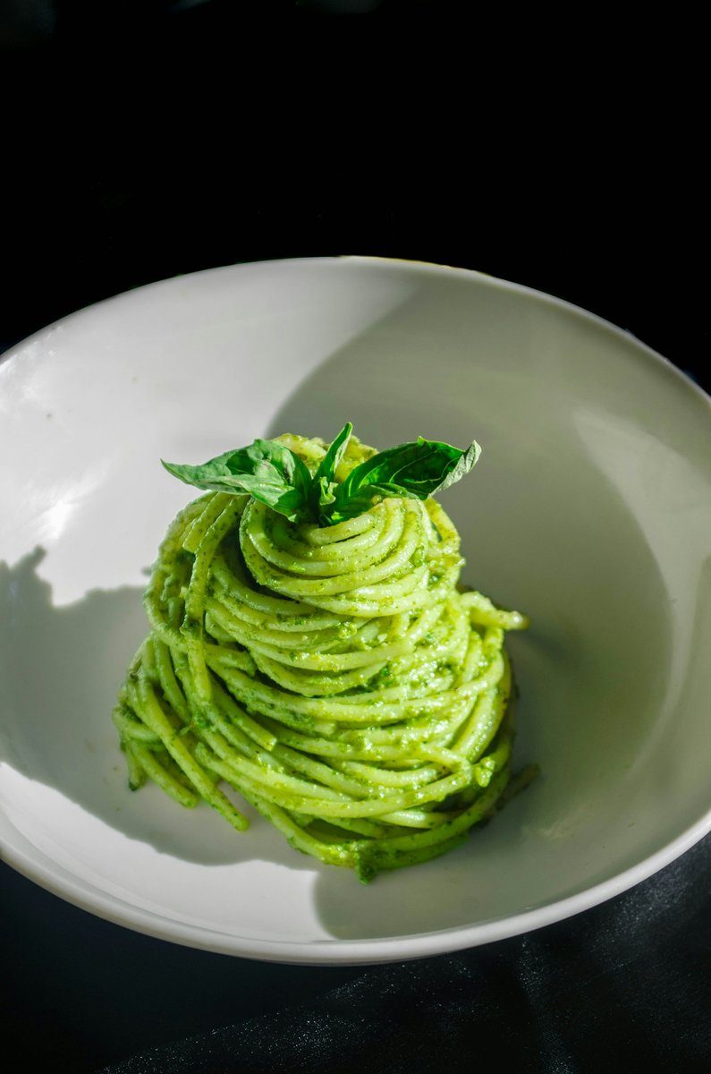 Assiette de spaghettis verts garnis de basilic